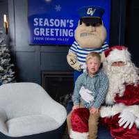 Boy sits on Santa's lap with Louie standing behind